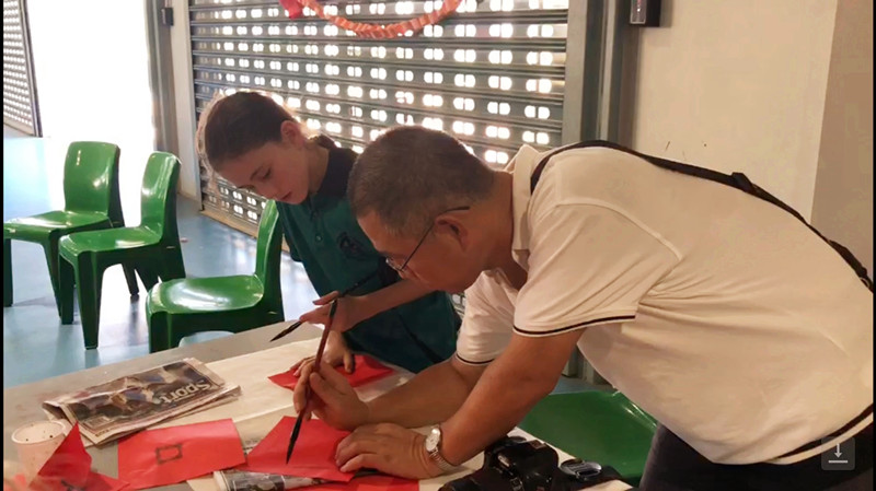 cd0f807580c56c4a1a053b13ed1e92f6.jpg 图五:学生在活动现场体验中国书法_副本.jpg
